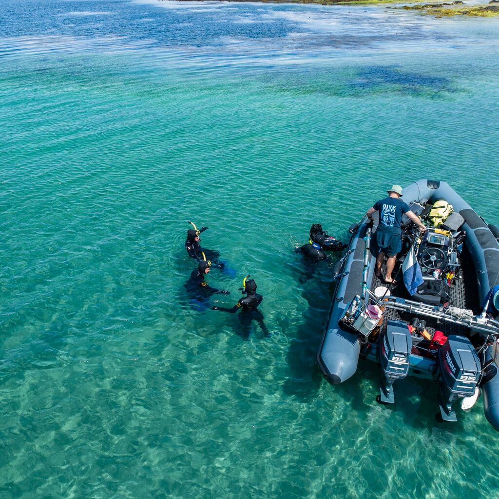 boat and snorkelers in clear Atlantic waters near inishmore