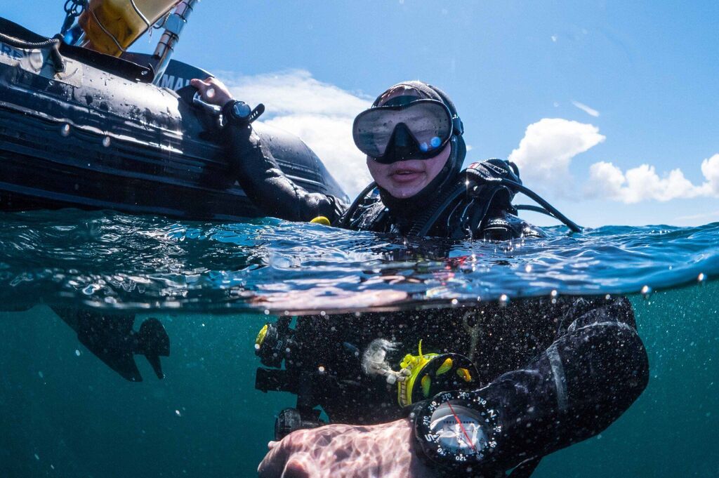 diver in the water holding the boat after scuba diving in Aran Islands