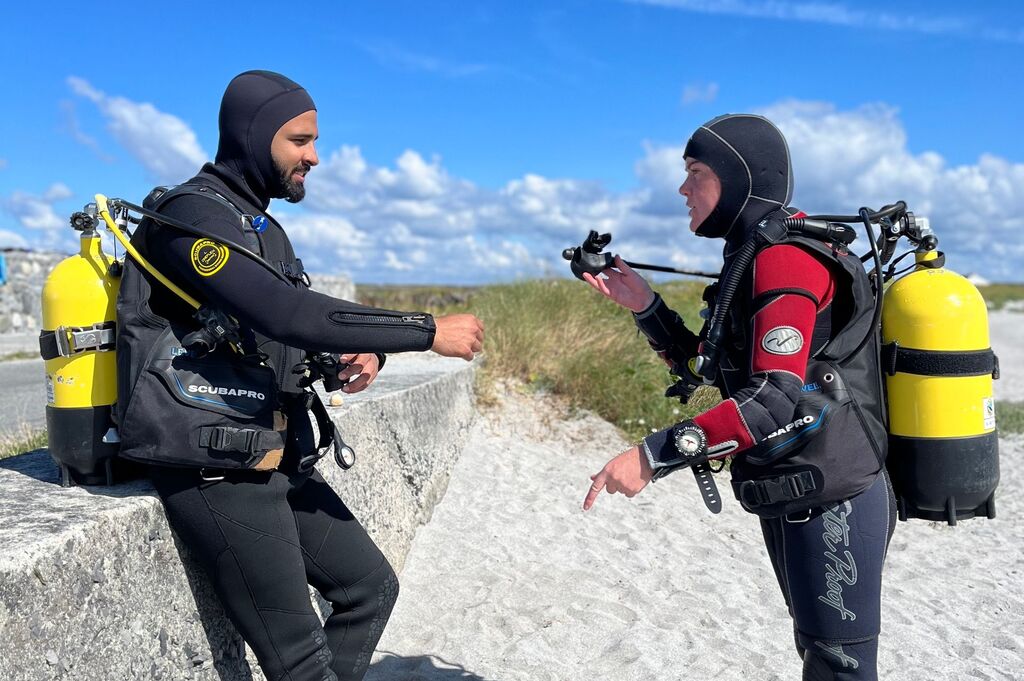 Divemaster teach student how to use dive gear on the beach before go in the water in Inishmore, aran islands