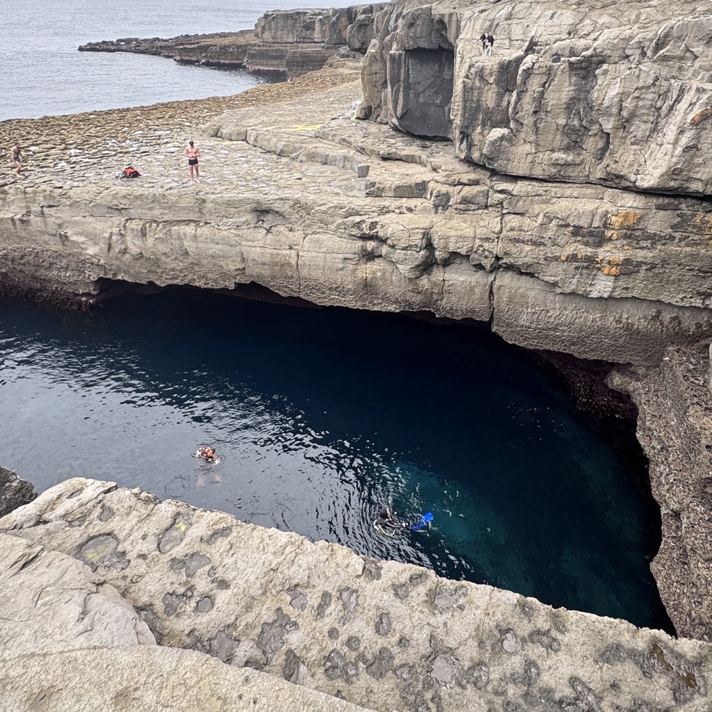 Scuba divers underwater and swimmers all enjoying swimming the Wormhole