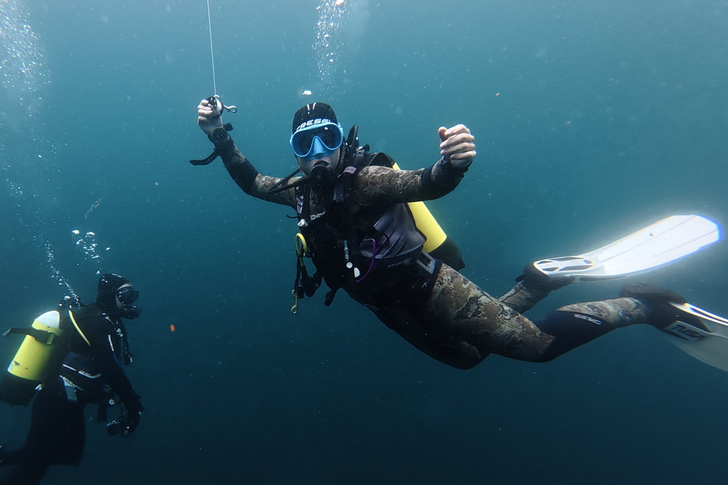 scuba diver underwater holds reel during safety stop near Inishmore, Aran islands